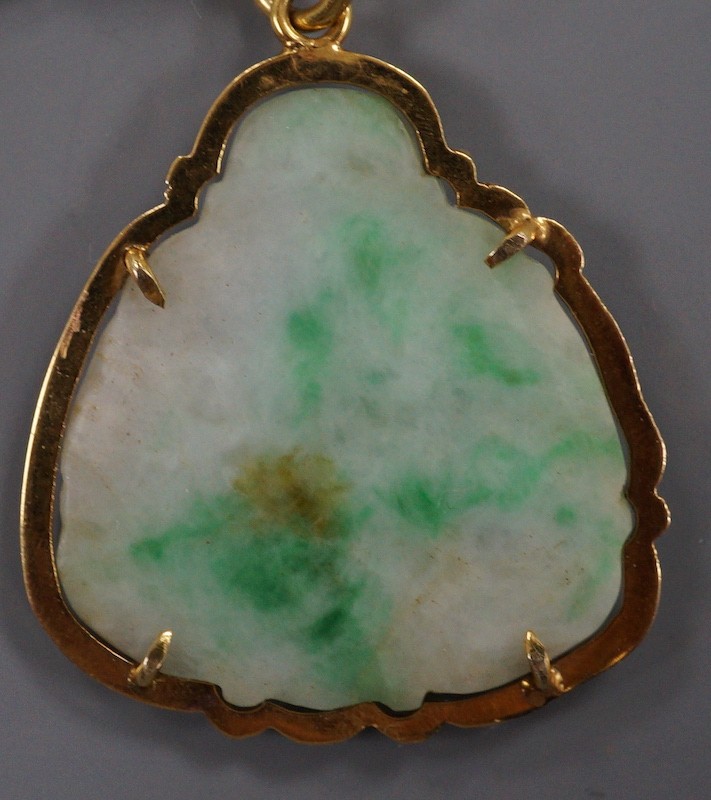 A yellow metal mounted jade pendant, carved with a Buddha, 32mm.